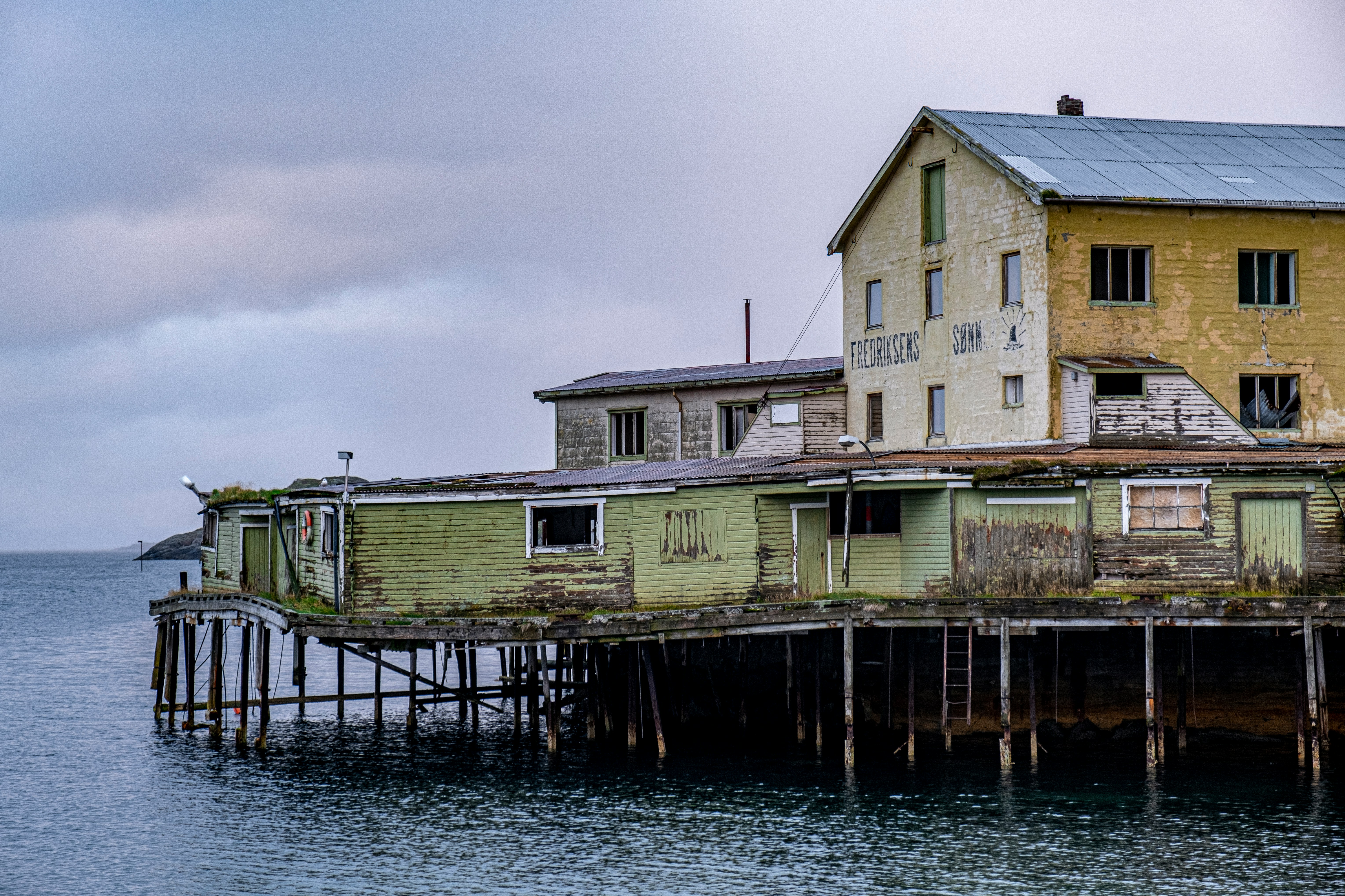 A weathered house on pilings beside the sea